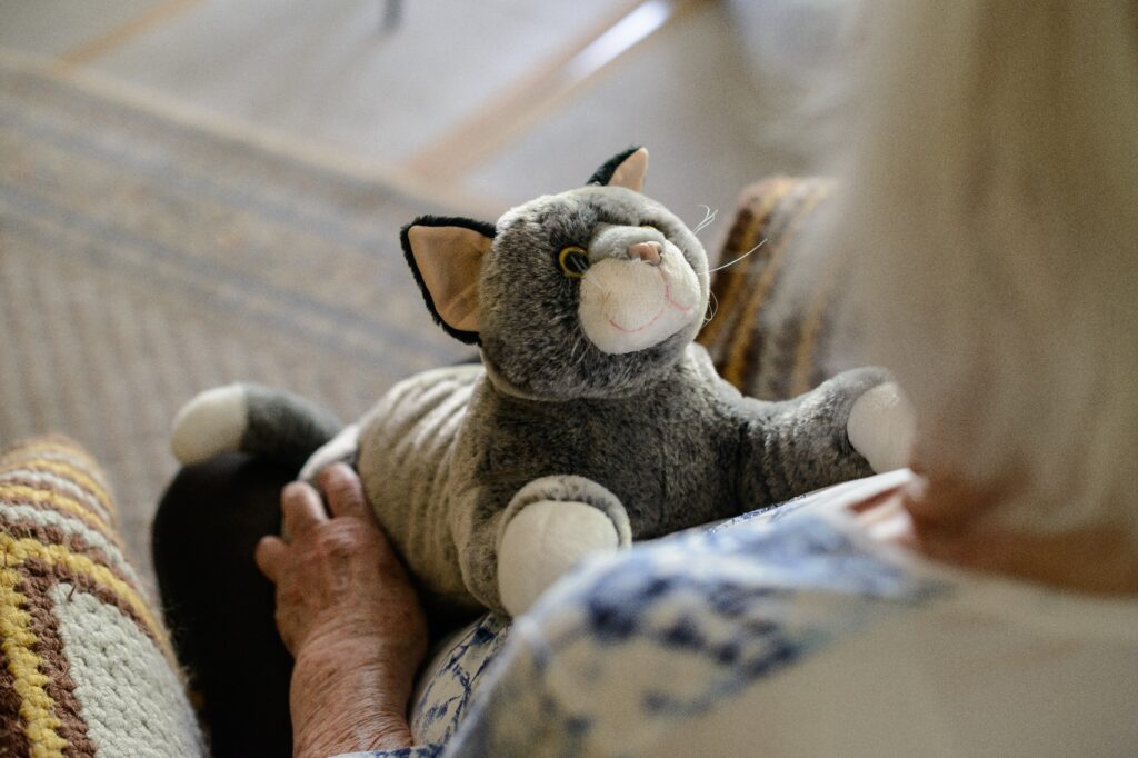 RobiCare Smart Cat auf dem Schoss einer älteren Dame.
